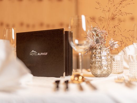 Romantik in den Bergen Elegantes Hotelrestaurant mit Tischdekoration und Karte vom Hotel Alphof