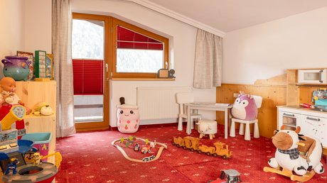 An inside look at our hotel in Stubaital in Fulpmes Kids playroom with toys, stuffed animals, and red carpet