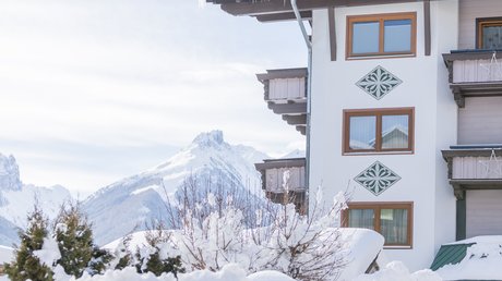 Einblicke in unser Hotel im Stubaital in Fulpmes Schneebedecktes Haus mit Bergen im Hintergrund und vereisten Dachrinnen