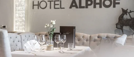 Set table in the hotel restaurant beneath the Hotel Alphof sign
