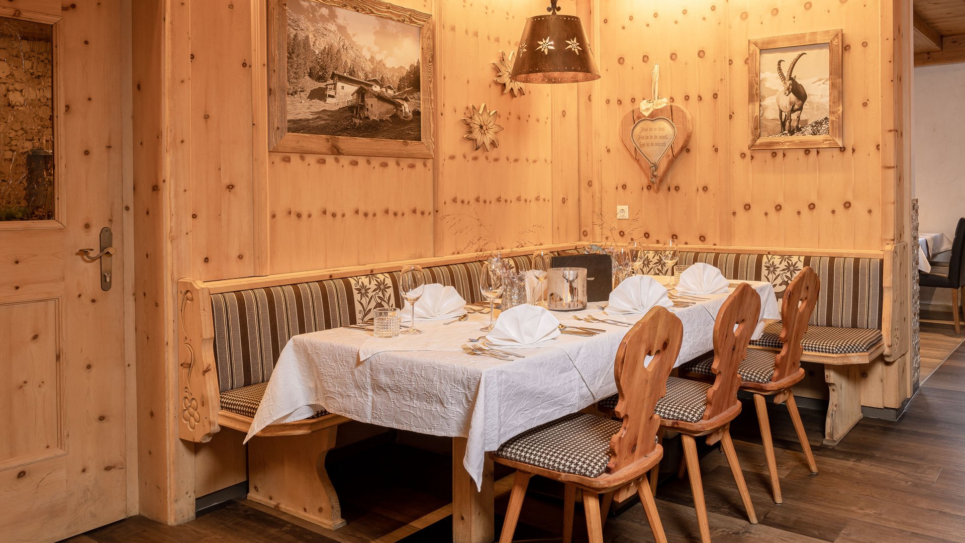 Romantik in den Bergen Traditioneller, gedeckter Esstisch in rustikaler Holzecke mit Teppichboden