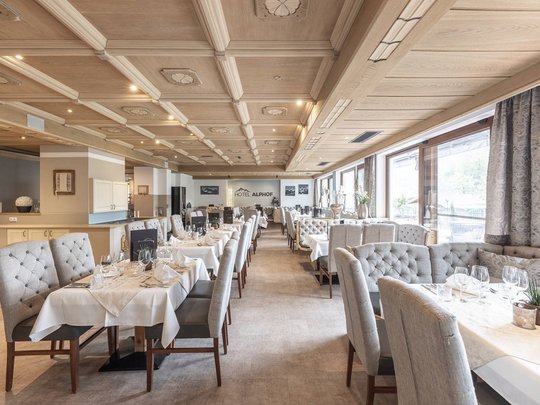 Ein feines Wellnesshotel in Fulpmes Elegantes Restaurant mit gedeckten Tischen und Holzbalkendecke im Hotel Alphof