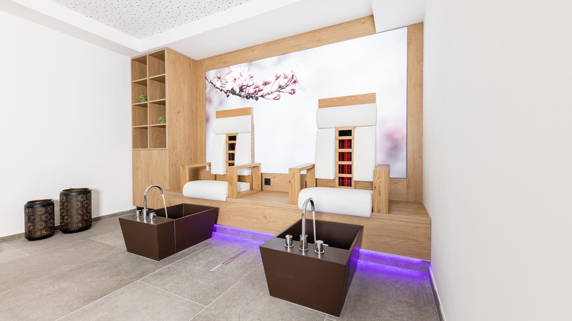 Unser Wellnesshotel im Stubaital Moderner Fußbadbereich mit zwei Holzsesseln und Waschbecken in einem hellen Raum
