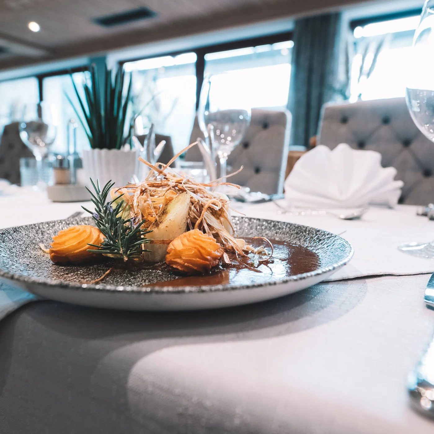 Alphof | genuine indulgence at a gourmet hotel in Tyrol Set restaurant table with an artfully arranged gourmet dish