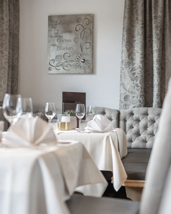 Elegant restaurant table with white tablecloth, wine glasses and cloth napkins