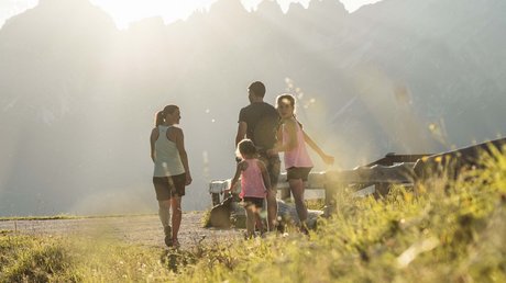 Einblicke in unser Hotel im Stubaital in Fulpmes Familie geht bei Sonnenuntergang in den Bergen spazieren