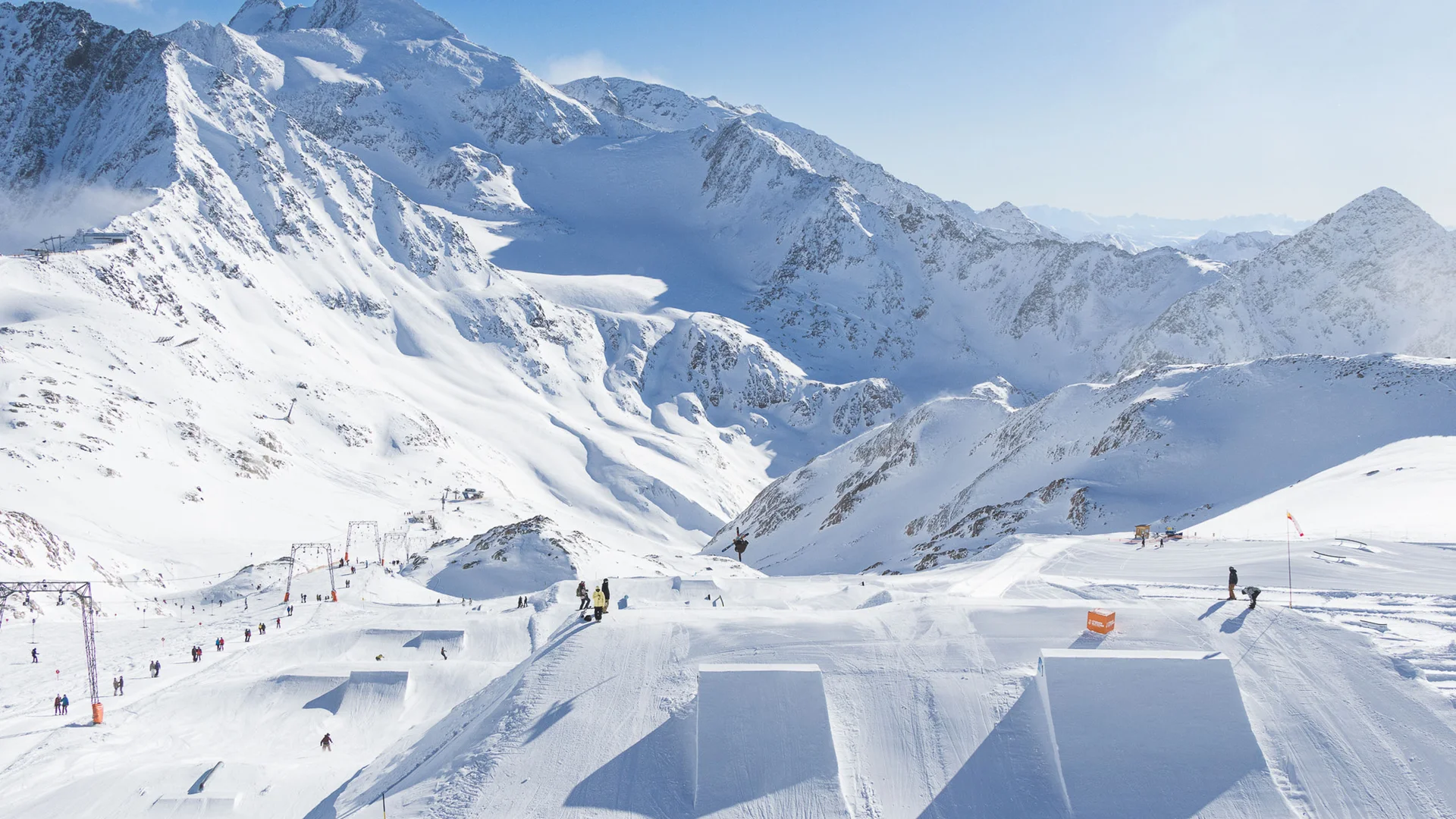 Snowy mountain landscape with ski lift and groomed jumps