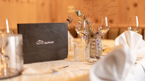 Summer or winter holiday in Tyrol: Hotel Alphof in Fulpmes Elegant table setting with Hotel Alphof menu and floral centerpiece