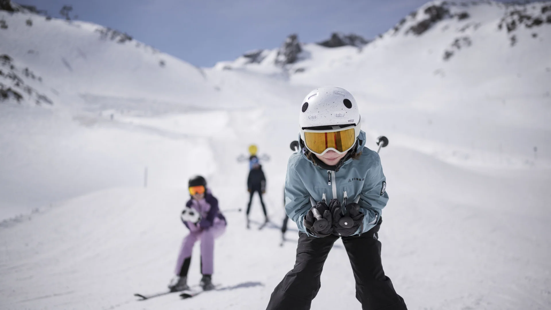 Child wearing a helmet and ski goggles on a snowy ski slope