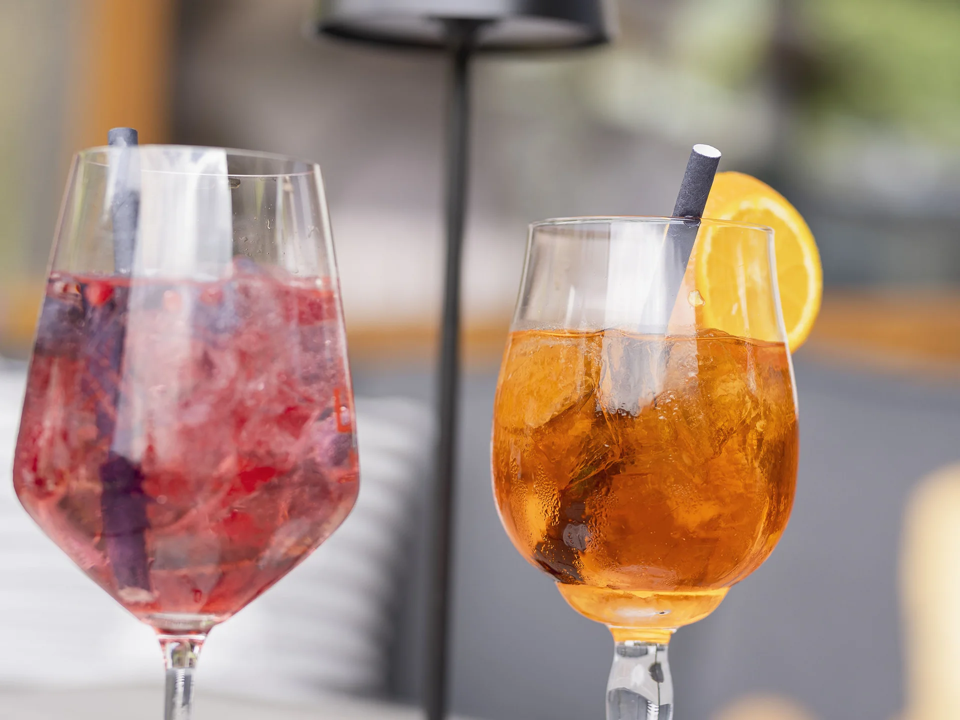 Alphof | genuine indulgence at a gourmet hotel in Tyrol Two colorful cocktails in glasses on a table with a black table lamp