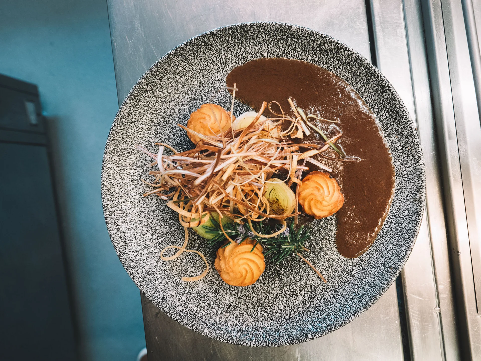 Alphof | genuine indulgence at a gourmet hotel in Tyrol Gourmet dish with dark sauce, orange rosettes and crispy vegetable strips