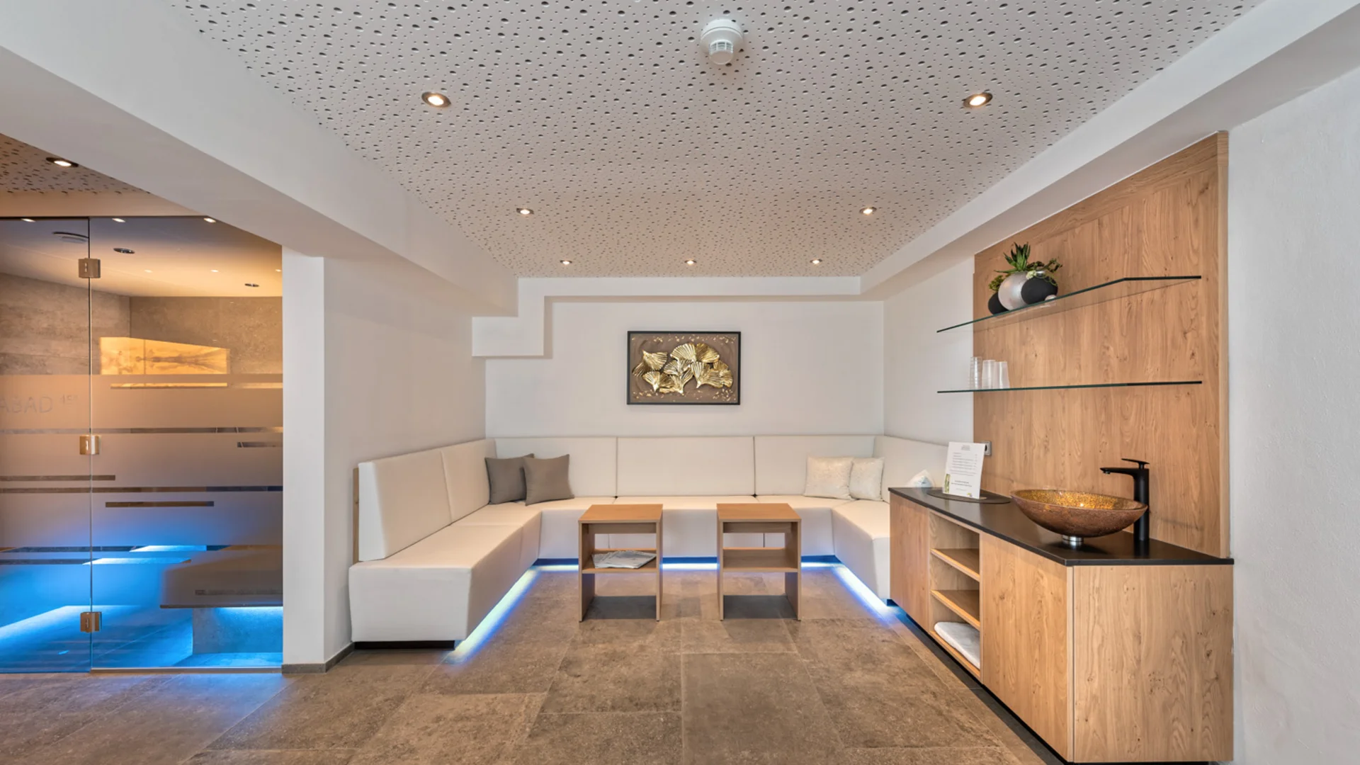Modern lounge area with seating, wooden furniture and adjacent sauna