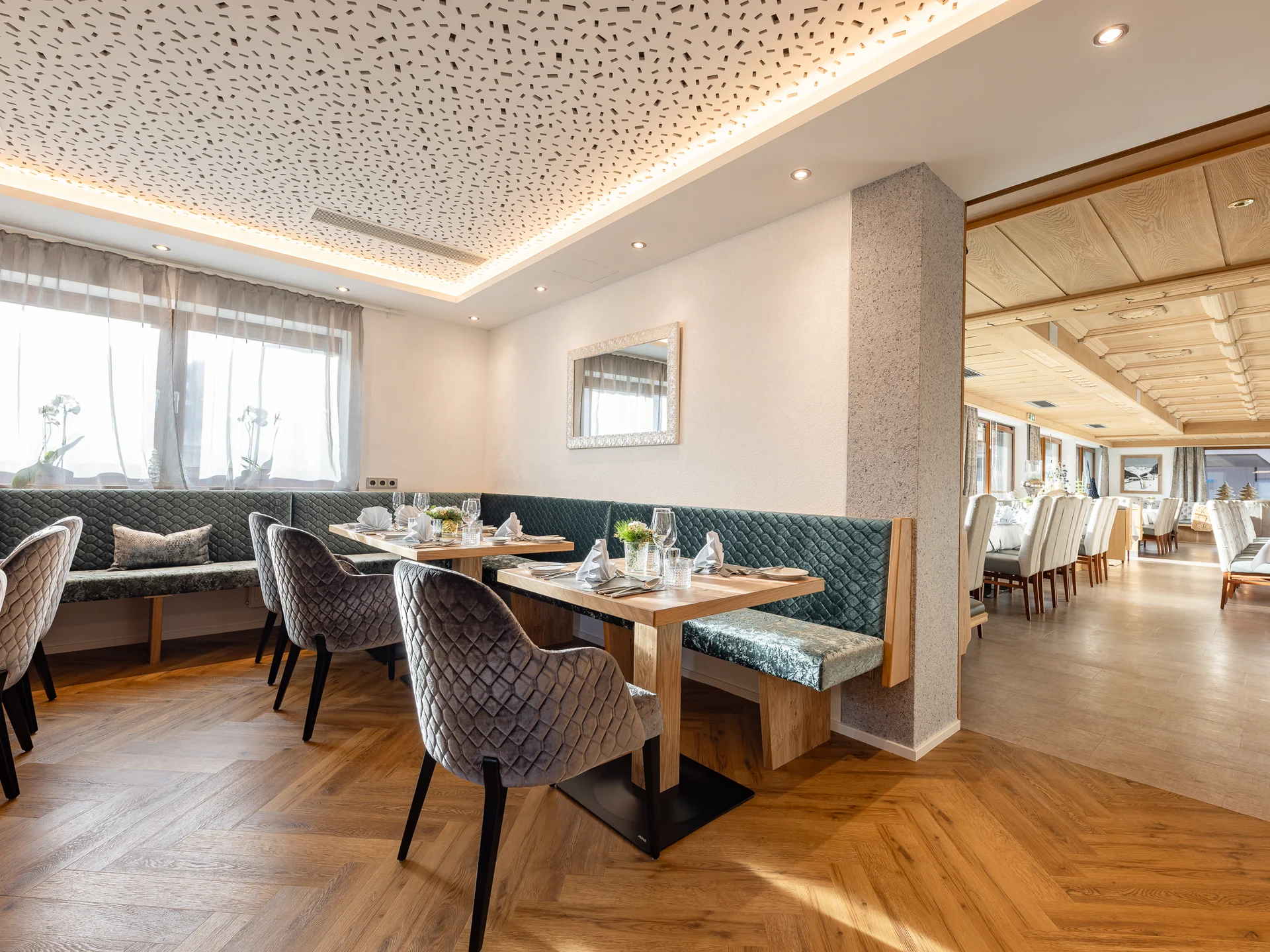Alphof | genuine indulgence at a gourmet hotel in Tyrol Elegant restaurant with set tables, upholstered chairs and bench seating