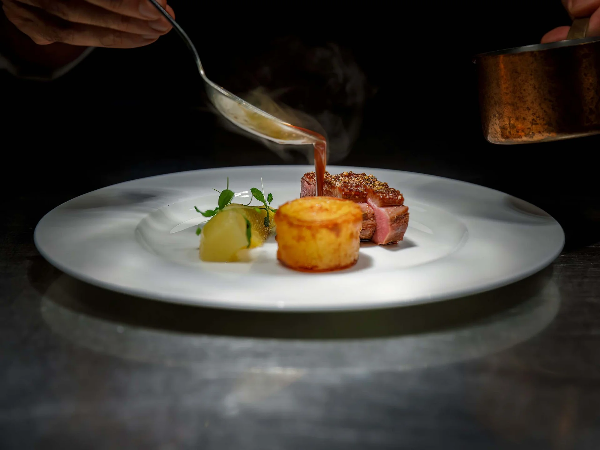 Alphof | genuine indulgence at a gourmet hotel in Tyrol Gourmet dish with meat, sides and sauce being plated on a white plate