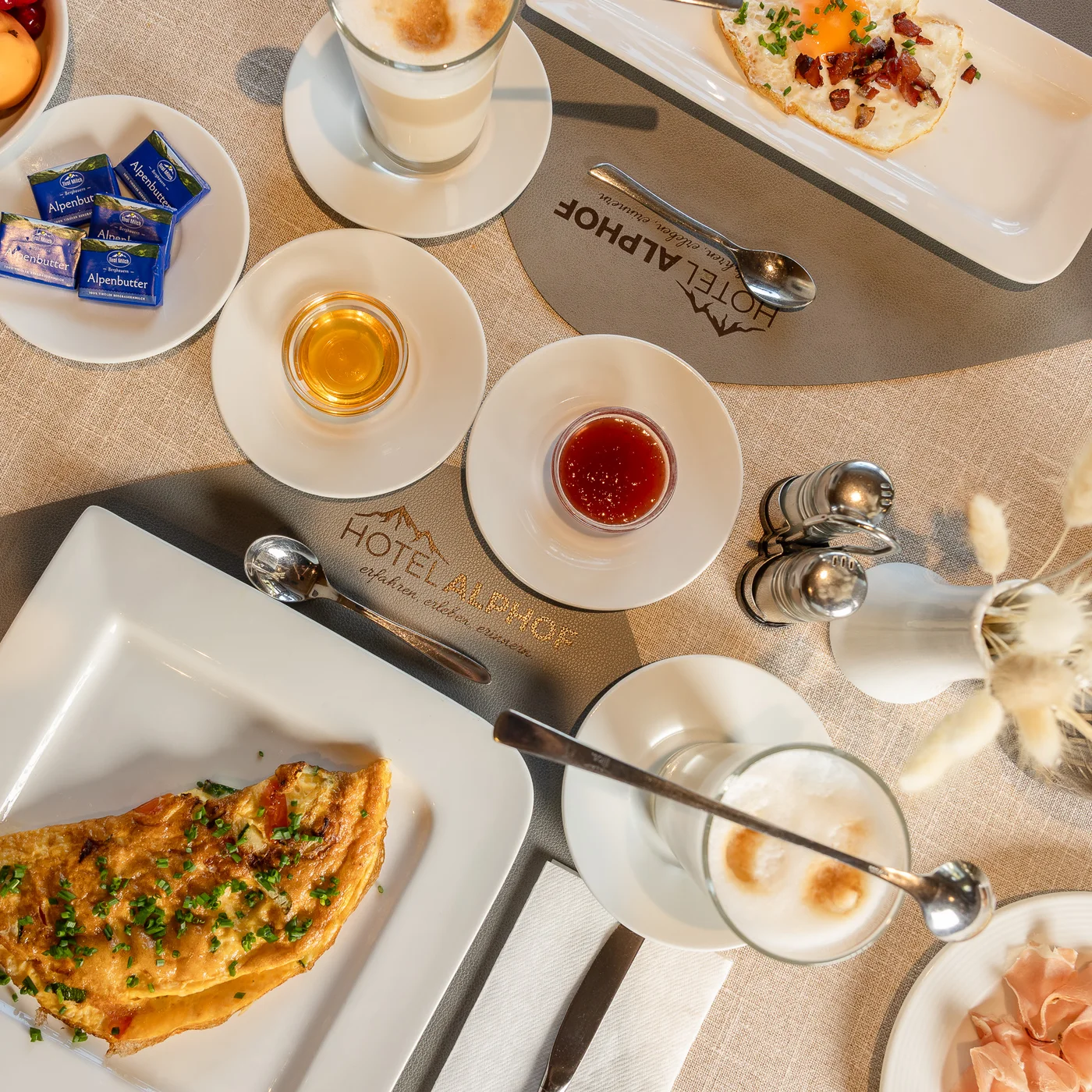 Alphof | genuine indulgence at a gourmet hotel in Tyrol Breakfast table with omelet, fruit, rolls, coffee, jam and cold cuts