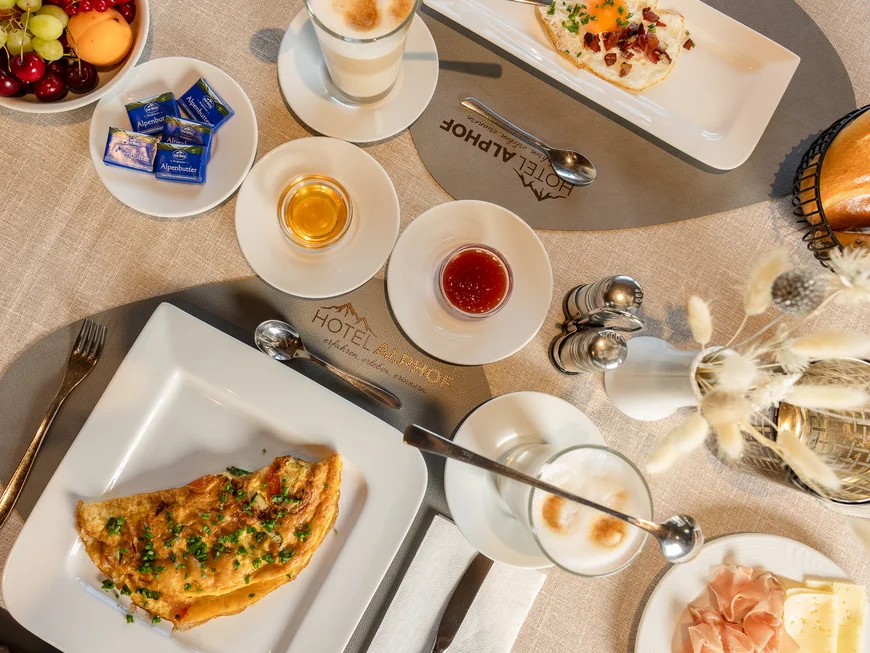Alphof | genuine indulgence at a gourmet hotel in Tyrol Breakfast table with omelet, fruit, rolls, coffee, jam and cold cuts