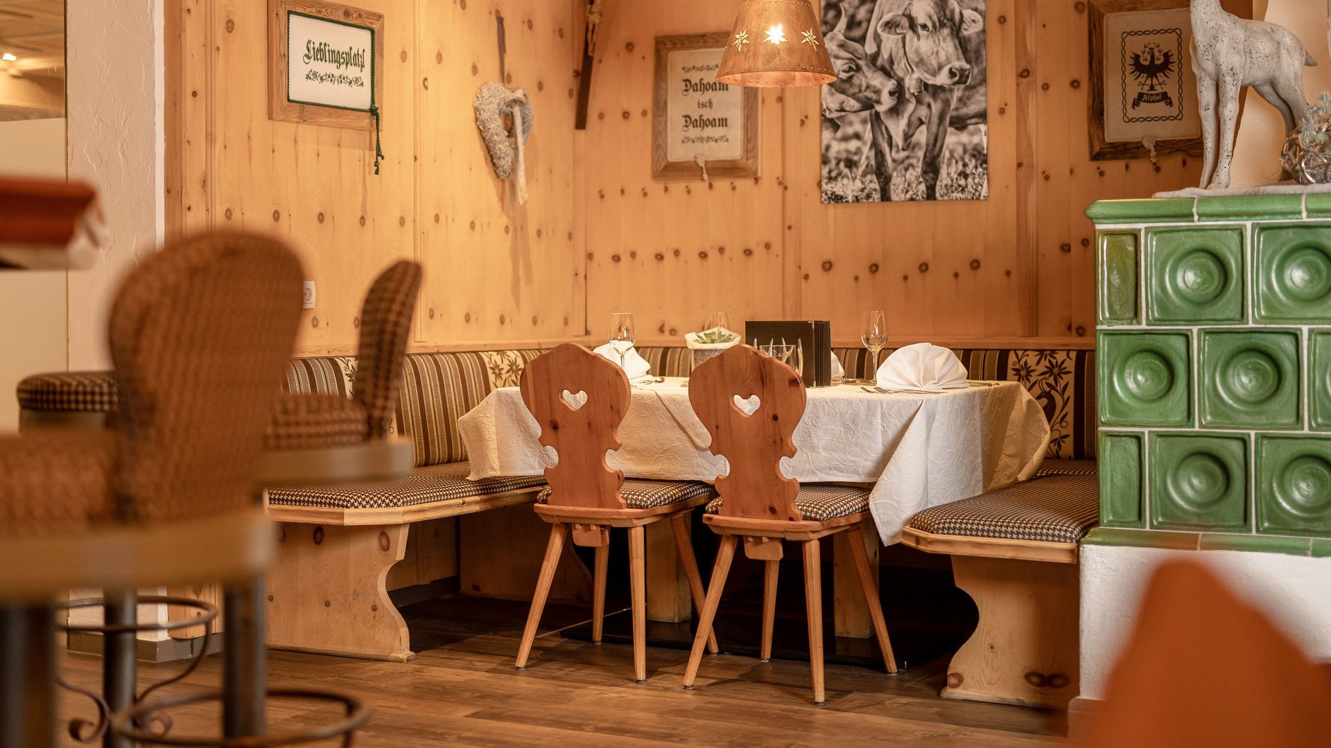 My hotel in Fulpmes in Stubaital Cozy wooden corner bench with tables, chairs, and alpine decorations in restaurant