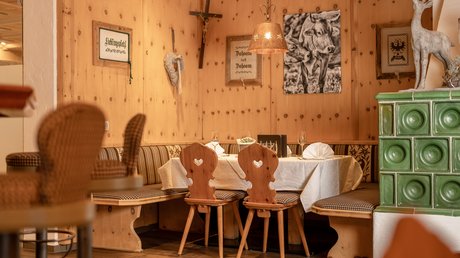 Einblicke in unser Hotel im Stubaital in Fulpmes Gemütliche Holz-Eckbank mit Tischen, Stühlen und Alpen-Dekoration im Restaurant