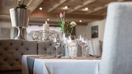 Einblicke in unser Hotel im Stubaital in Fulpmes Eleganter gedeckter Tisch in Restaurant mit Blumen und Kerze