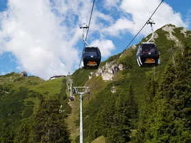 Hotel Alphof | your basecamp for walking holidays in Austria Cable cars over forested mountains beneath a blue sky