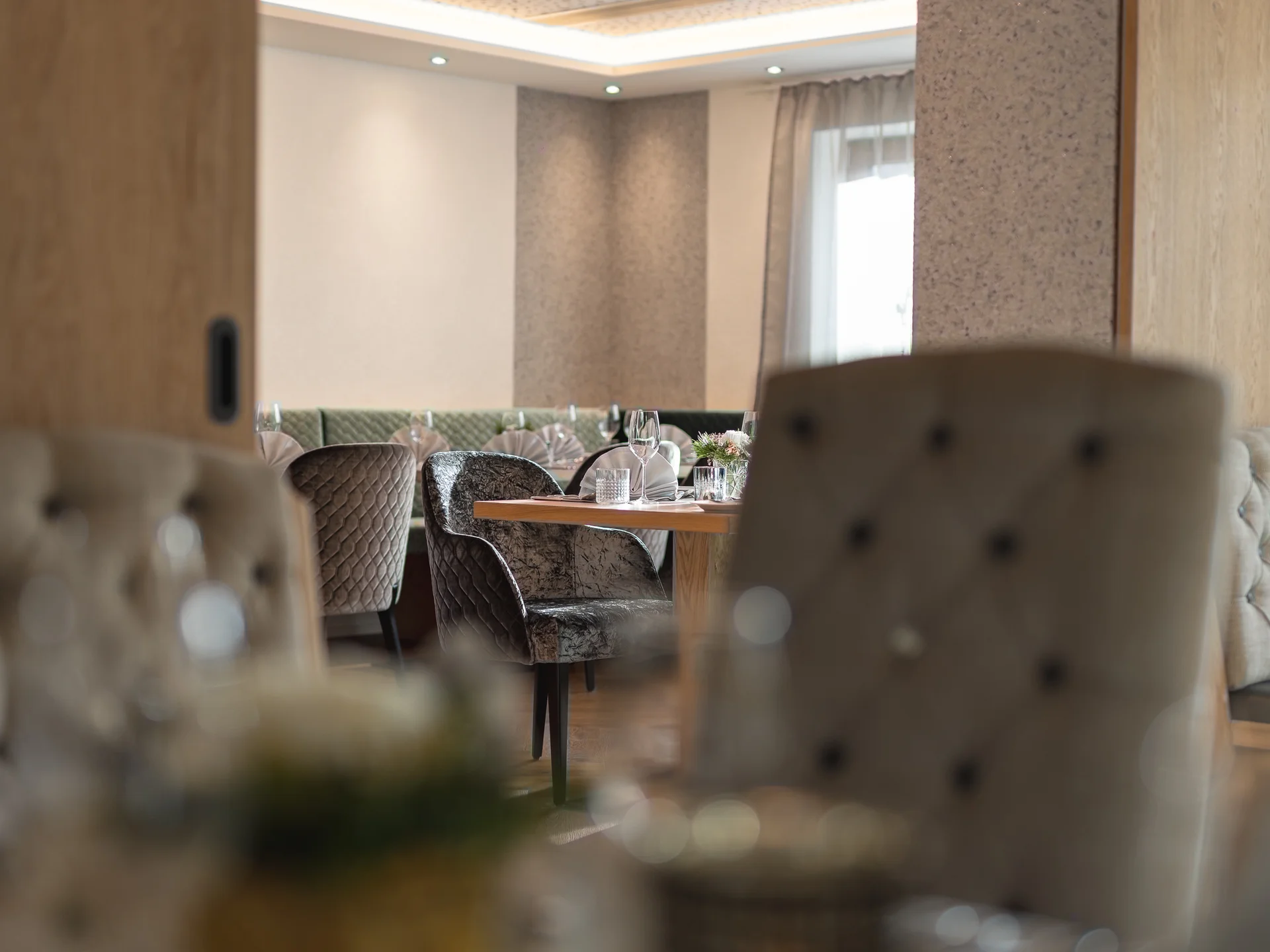 Der Alphof | Ihr Hotel in Fulpmes Eleganter Restaurantbereich mit gedecktem Tisch und gepolsterten Sitzmöbeln