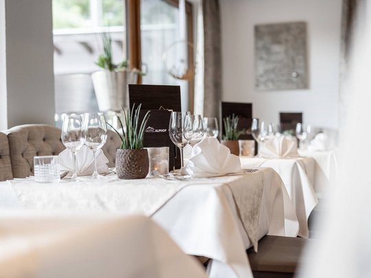 Ein feines Wellnesshotel in Fulpmes Elegante gedeckte Tische mit Wein- und Wassergläsern im Hotelrestaurant