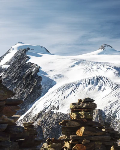Hotel Alphof | your basecamp for walking holidays in Austria Snow-covered glacier landscape with mountain peaks and stone cairns in the foreground