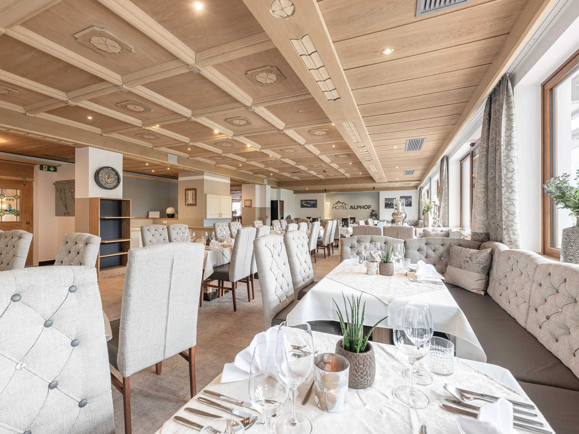 Alphof | genuine indulgence at a gourmet hotel in Tyrol Bright hotel dining room with set tables, upholstered chairs and large windows