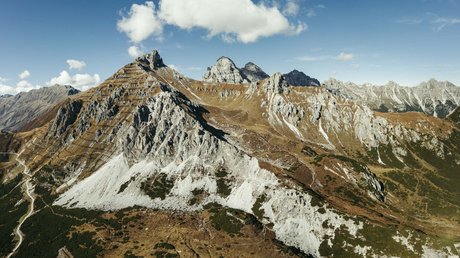 Einblicke in unser Hotel im Stubaital in Fulpmes Berglandschaft mit felsigen Gipfeln und bewaldeten Tälern unter blauem Himmel