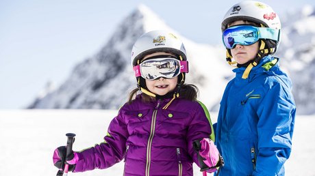 Einblicke in unser Hotel im Stubaital in Fulpmes Zwei Kinder in Skibekleidung und Helmen vor verschneiten Bergen