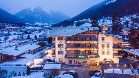 Einblicke in unser Hotel im Stubaital in Fulpmes Hotel Alphof in verschneitem Tal umgeben von Bergen bei Abenddämmerung