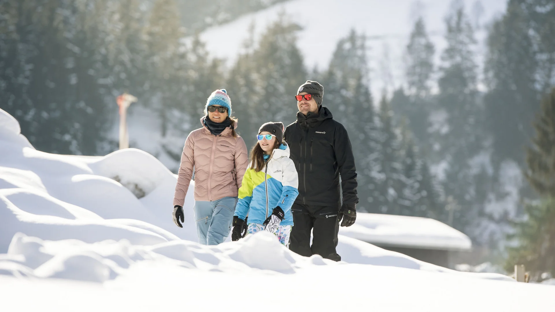 Family in winter clothing standing in a snowy forest