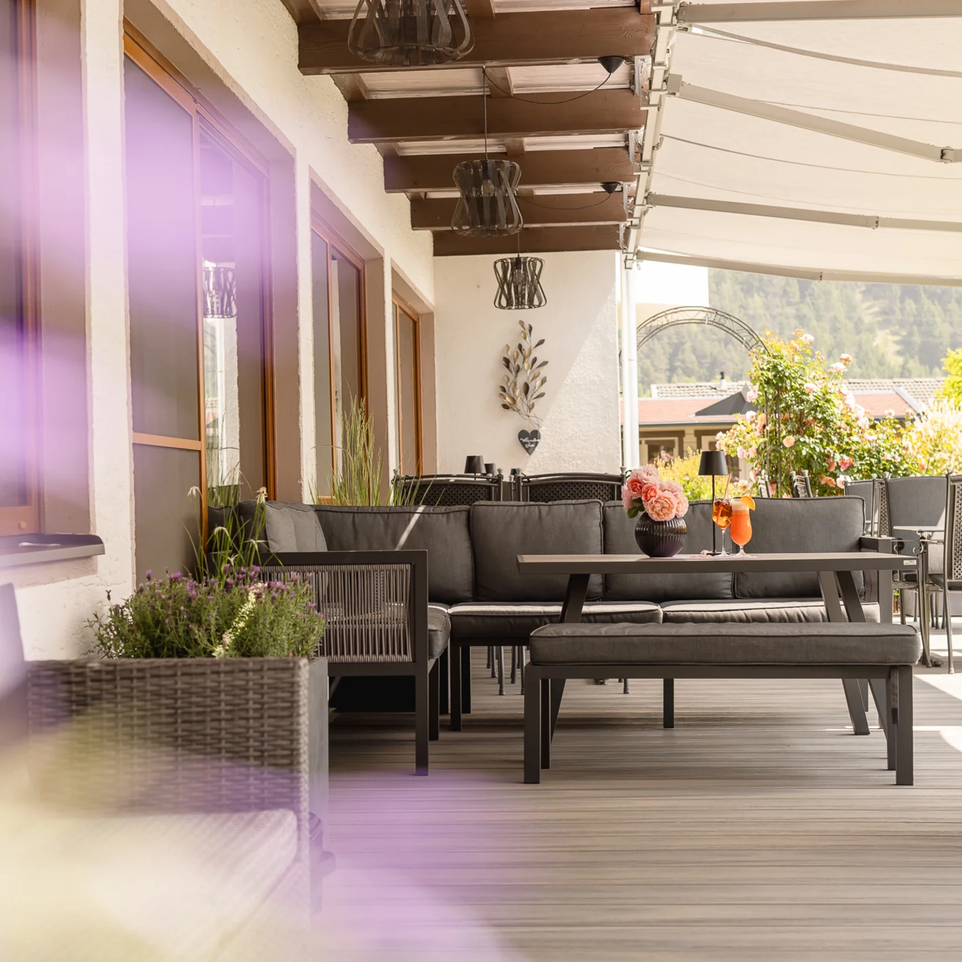 Garden and terrace at Hotel Alphof in Fulpmes, Tyrol Covered terrace with seating, plants and mountain views
