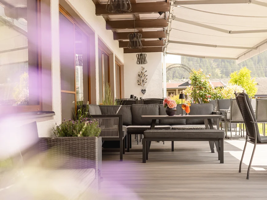 Garden and terrace at Hotel Alphof in Fulpmes, Tyrol Covered terrace with seating, plants and mountain views