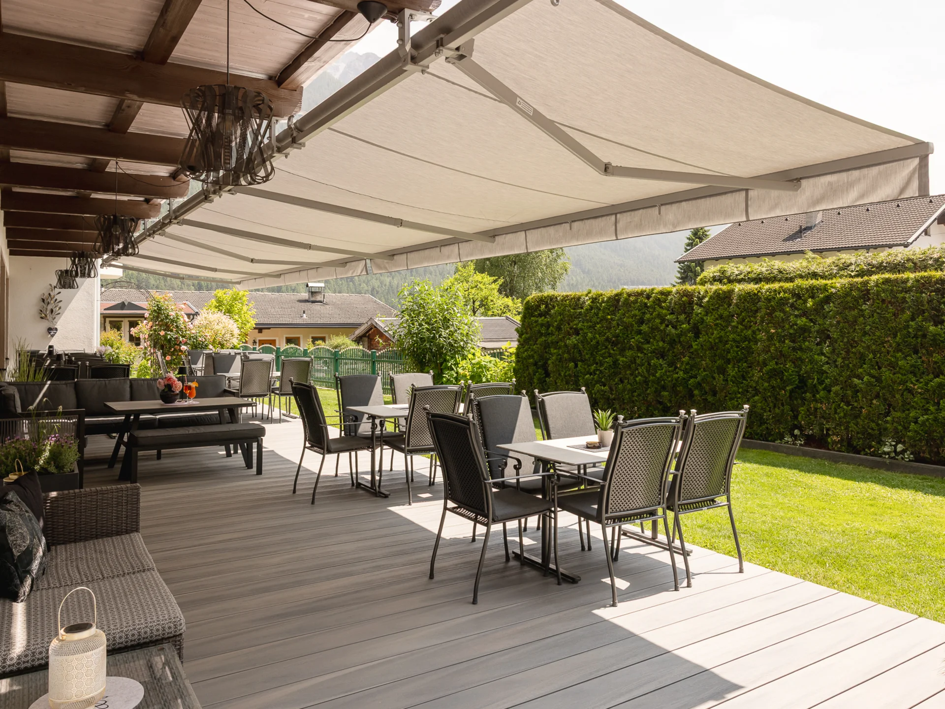 Garden and terrace at Hotel Alphof in Fulpmes, Tyrol Covered terrace with seating areas, garden and mountain views