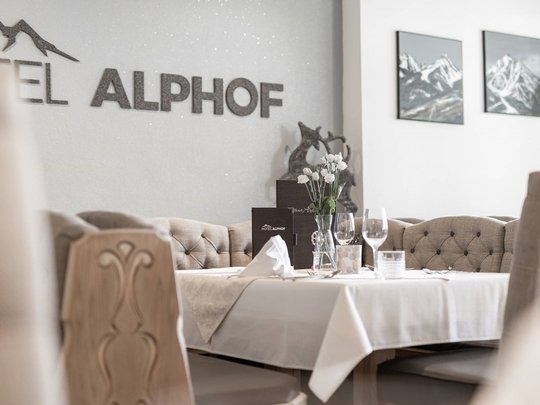 Ein feines Wellnesshotel in Fulpmes Eleganter gedeckter Tisch im Hotel Alphof mit Bergbildern an der Wand