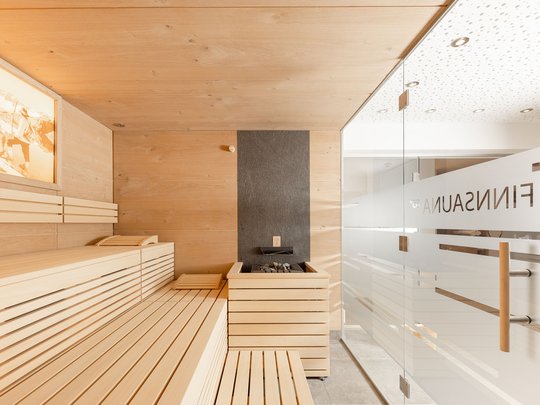 Unser Wellnesshotel im Stubaital Moderner finnischer Sauna-Raum mit Holzverkleidung und glastür