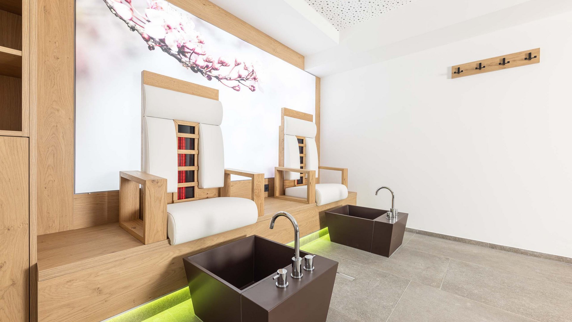 Ein feines Wellnesshotel in Fulpmes Moderne Pediküre-Ecke mit zwei bequemen Sesseln und Fußbädern in hellem Raum