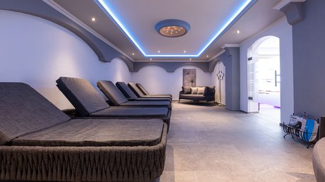 Einblicke in unser Hotel im Stubaital in Fulpmes Ruheraum mit mehreren Liegen und Sofa in einem modernen Wellnessbereich