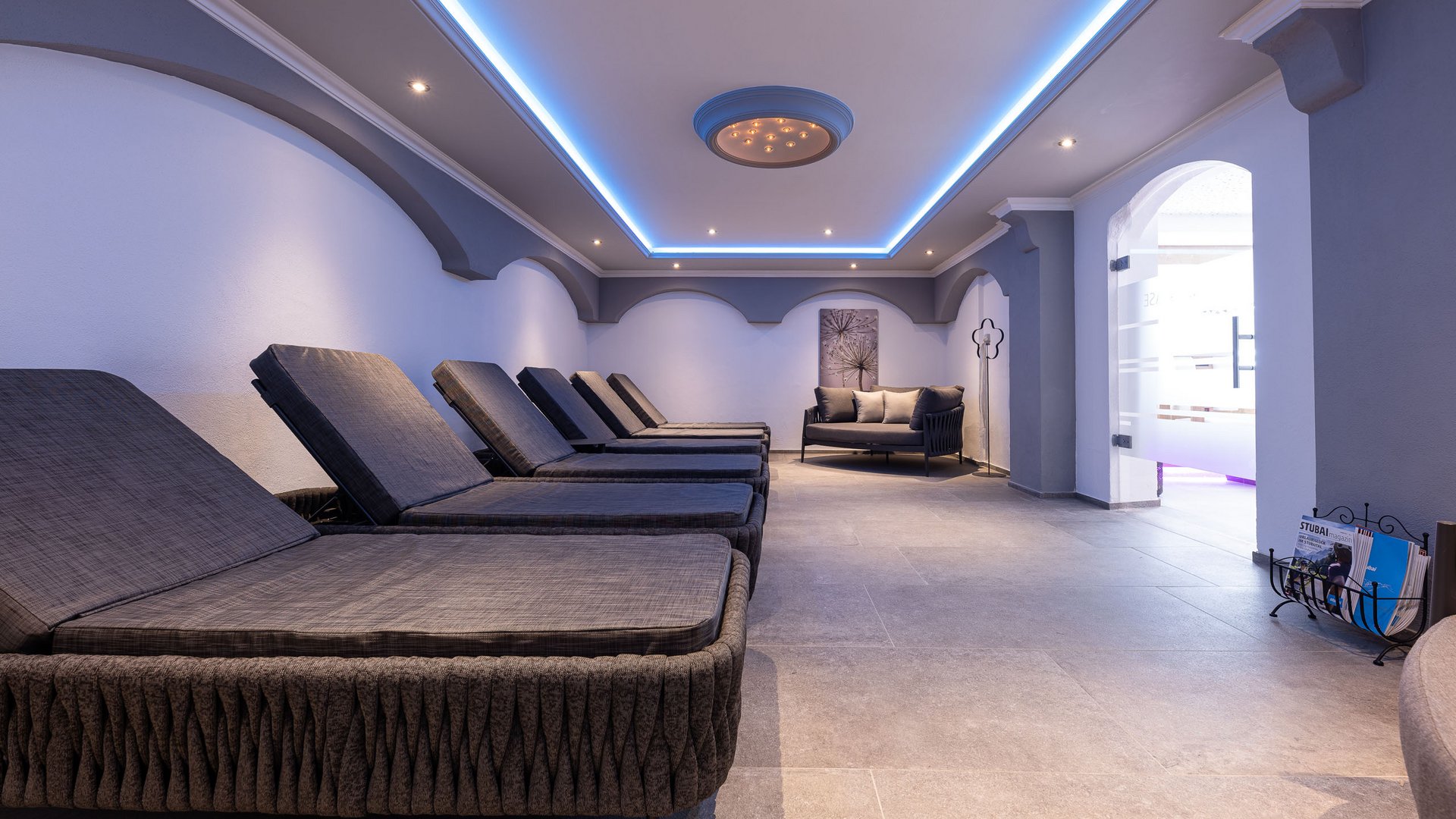 Ein feines Wellnesshotel in Fulpmes Ruheraum mit mehreren Liegen und Sofa in einem modernen Wellnessbereich