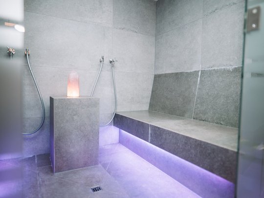 My hotel in Fulpmes in Stubaital Modern sauna room with gray tiles and purple LED lighting