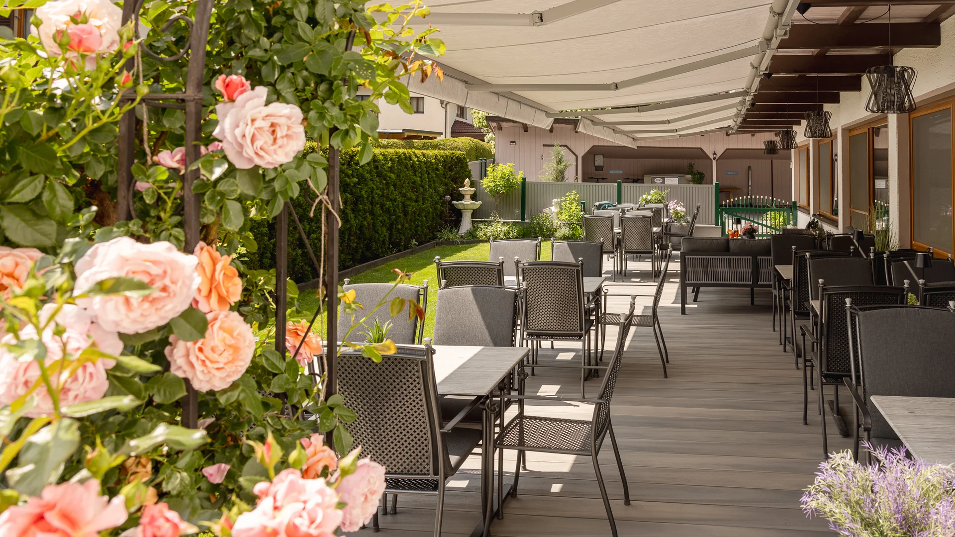 Covered terrace with seating and blooming roses