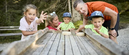 Family playing a wooden game in the forest