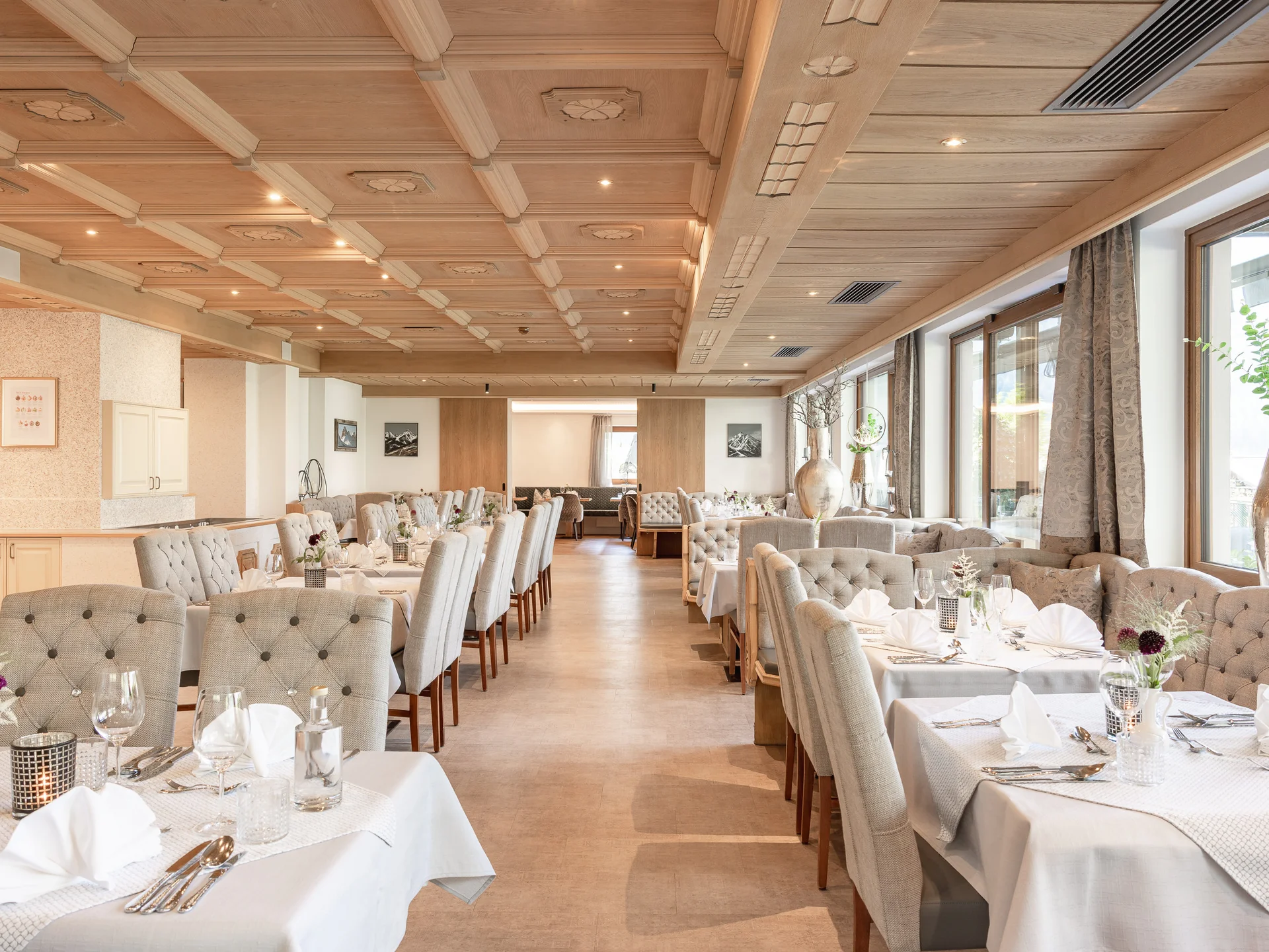 Der Alphof | Ihr Hotel in Fulpmes Elegantes Restaurant mit gedeckten Tischen, Polsterstühlen und großen Fenstern