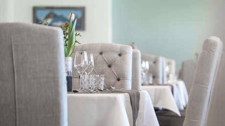 Einblicke in unser Hotel im Stubaital in Fulpmes Gedeckter Restauranttisch mit Gläsern und Blumen in modernem Ambiente