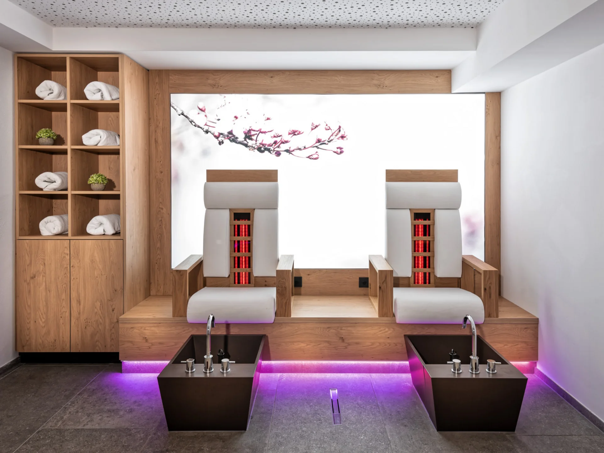The modern AlpSpa at your spa hotel in Tyrol Modern wellness room with two heated loungers, foot baths and towel shelving