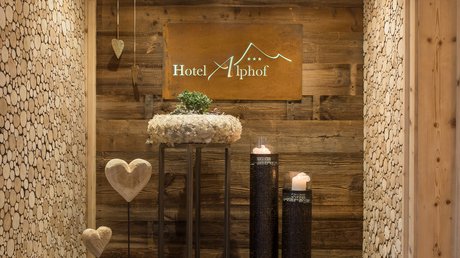 Einblicke in unser Hotel im Stubaital in Fulpmes Hotel Alphof Empfangsbereich mit Holzdecke und dekorativen Herzen