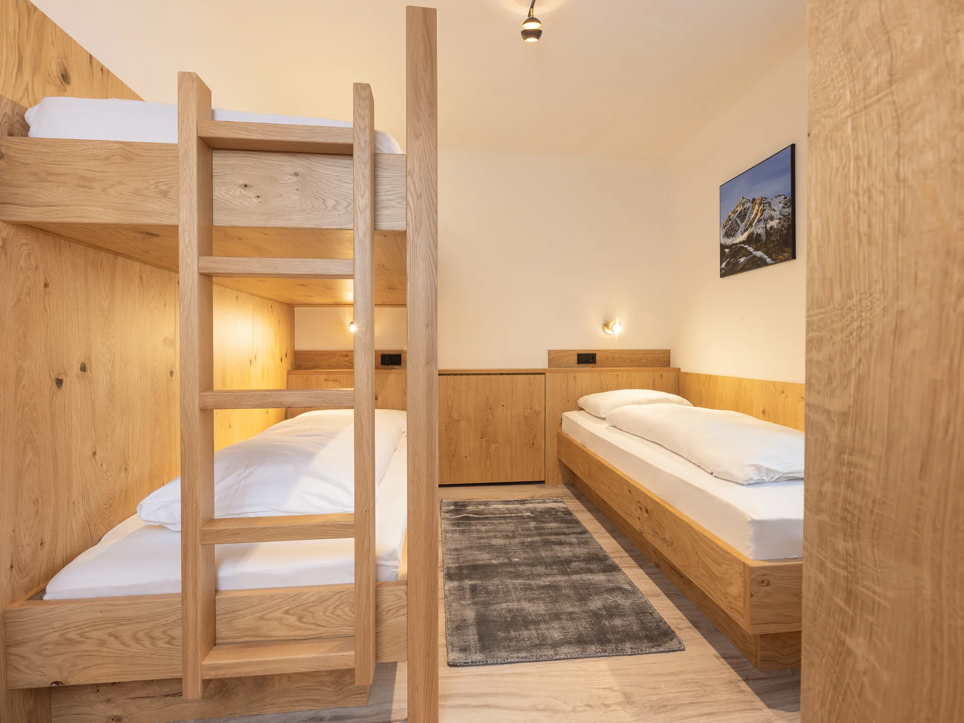 Der Alphof | Ihr Hotel in Fulpmes Holzzimmer mit Etagenbett, Einzelbett, Teppich und Wandbild