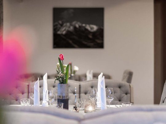 Romantik in den Bergen Eleganter gedeckter Tisch mit roten Tulpen und weißen Servietten in modernem Restaurant
