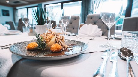 Einblicke in unser Hotel im Stubaital in Fulpmes Gourmetgericht kunstvoll auf grauem Teller bei feinem Tischgedeck